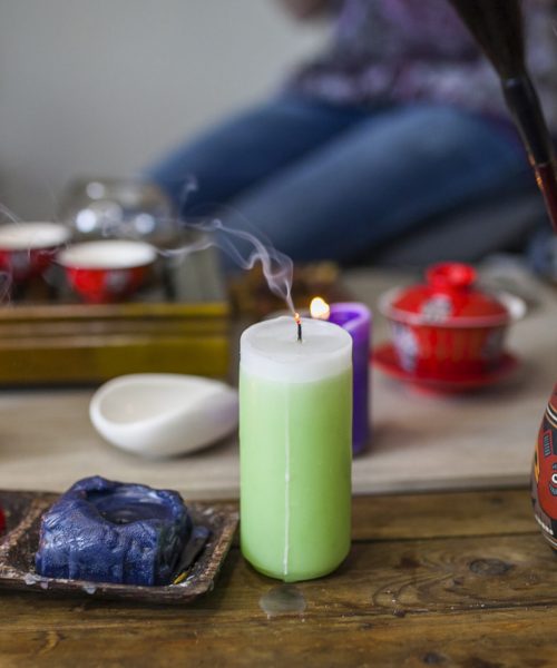 extinguished-candle-with-smoke-front-tea-set-wooden-table (1)